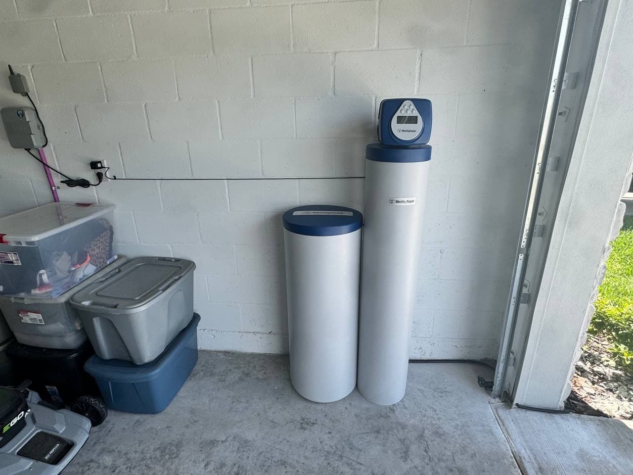 Installed whole-home water filtration system inside a Tampa Bay garage.