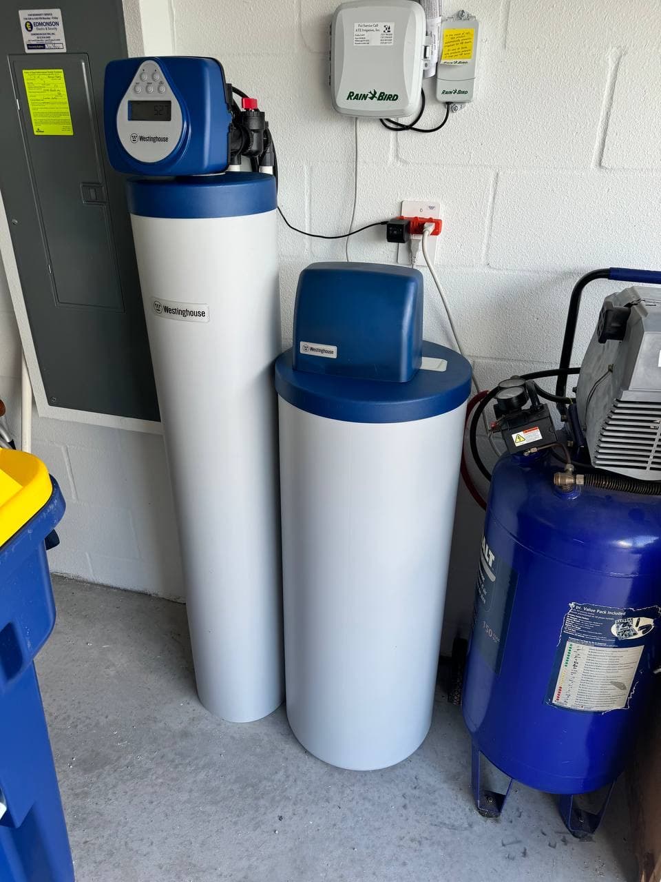 Whole-home water filtration and softening equipment installed in a Tampa Bay garage.