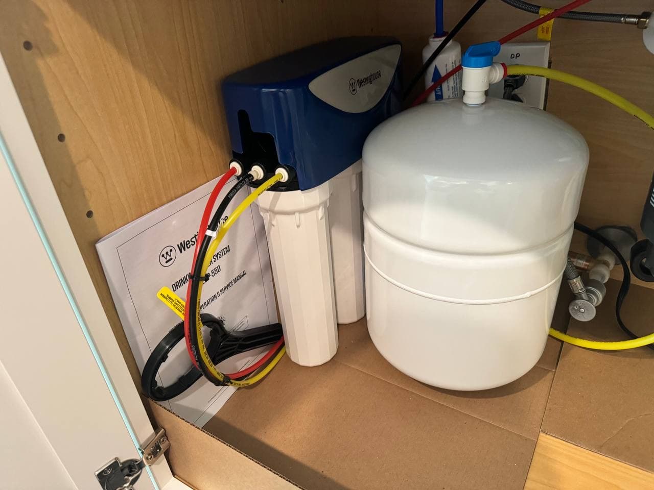 Under-sink drinking water filtration system with a storage tank.