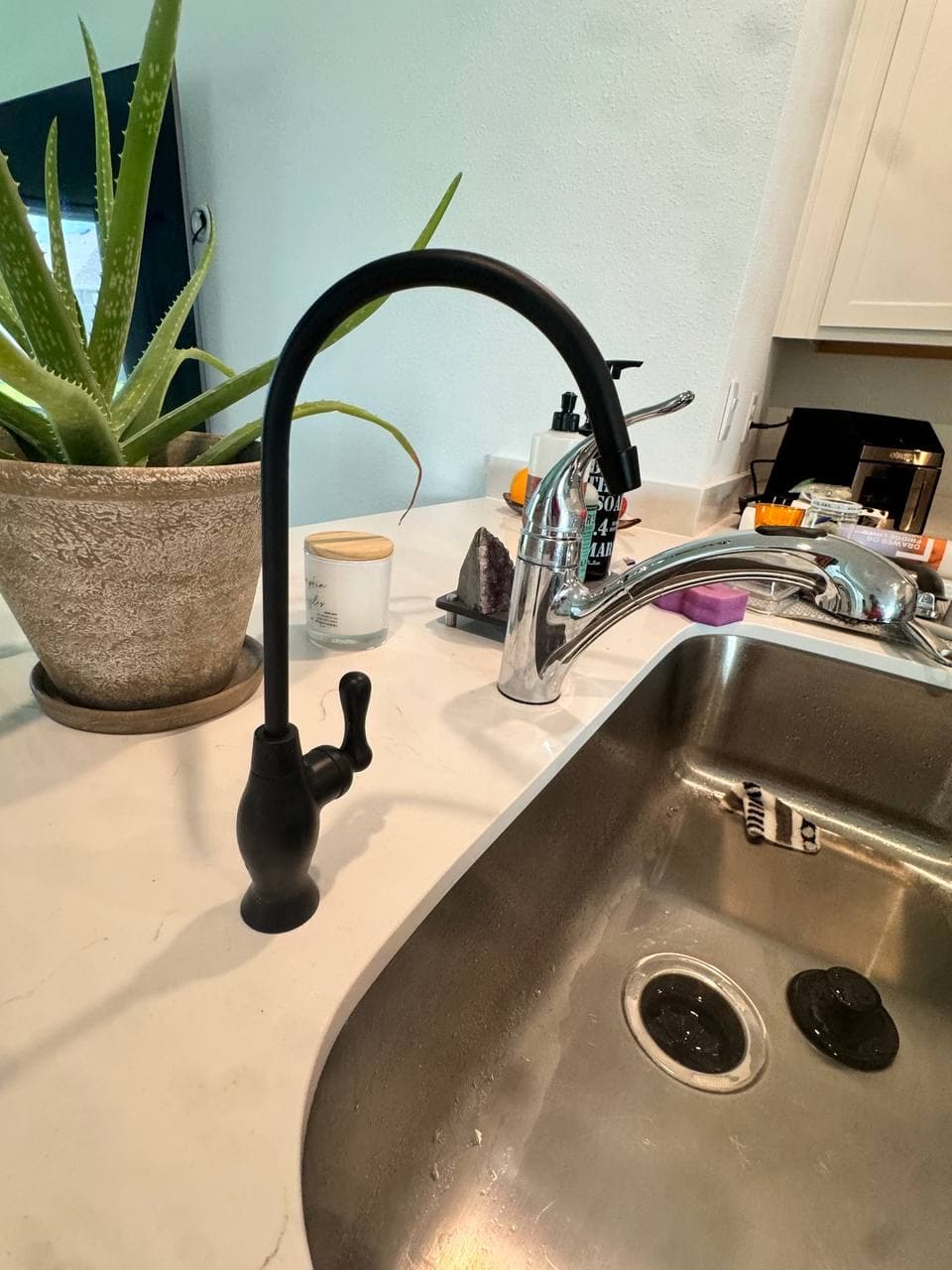 Kitchen drinking water faucet installed beside a sink.